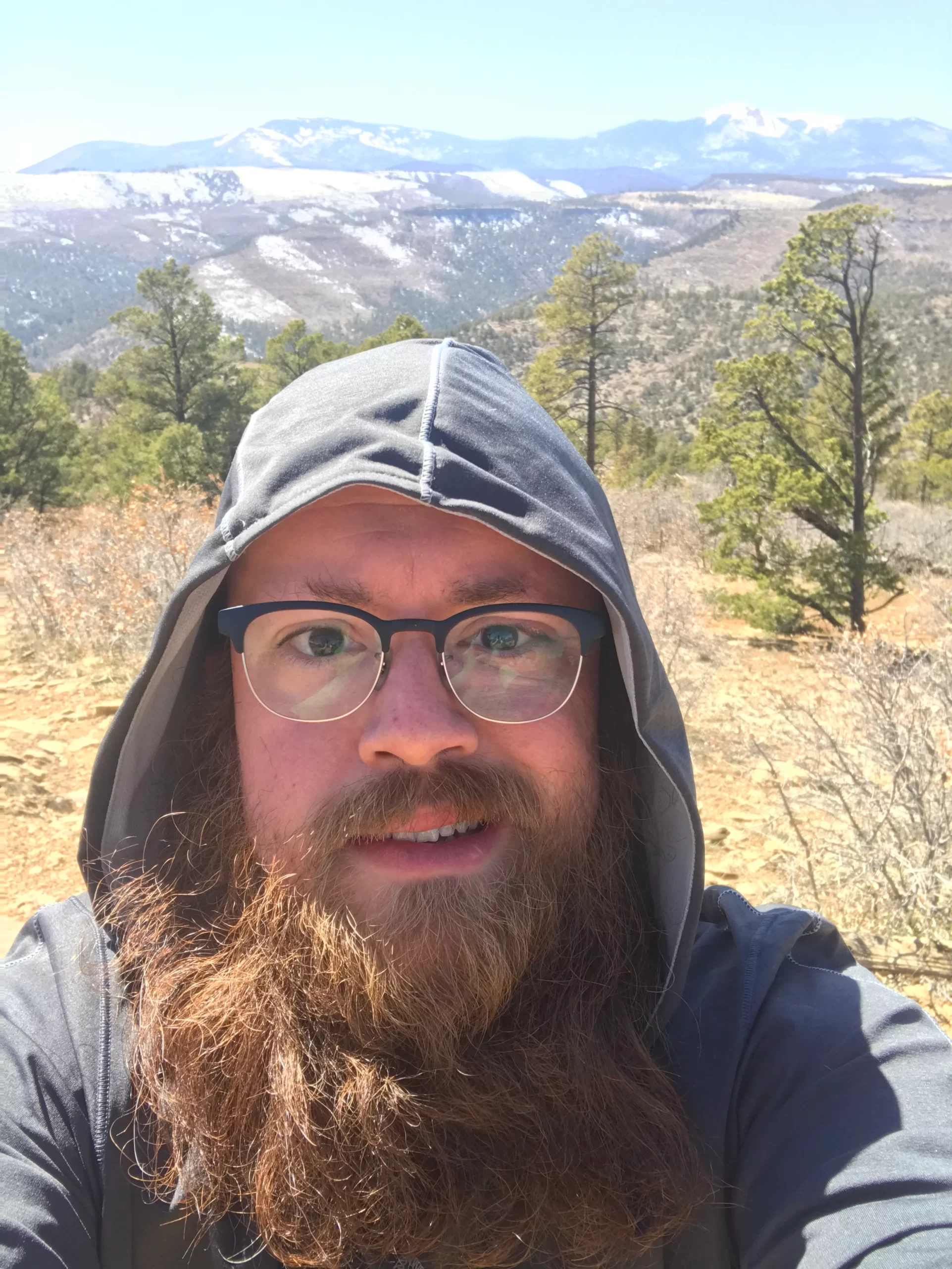 Shane Miller taking a selfie in front of a scenic mountain view